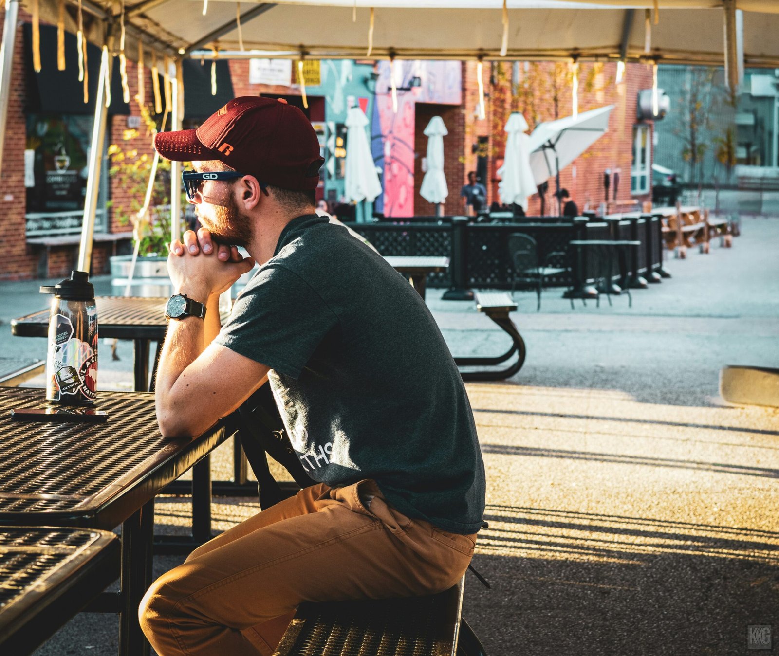 A man sitting at a table with a beer in his hand