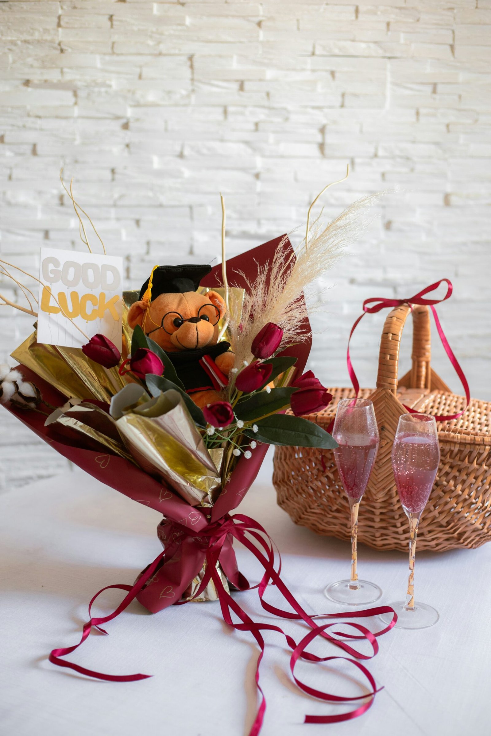 A basket of flowers next to a glass of wine